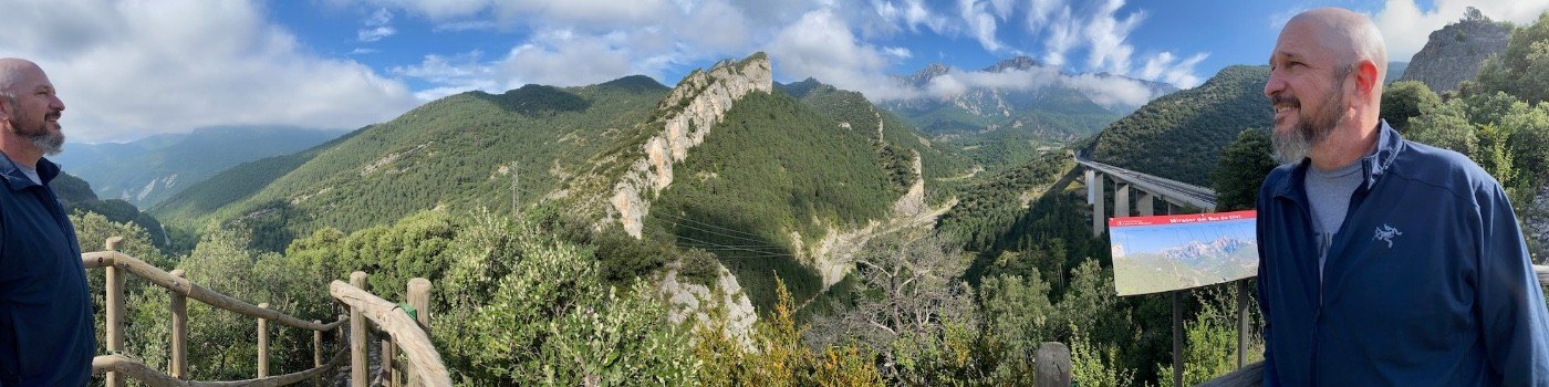 Panoramic mountain view with Mark appearing at both ends of the same photo